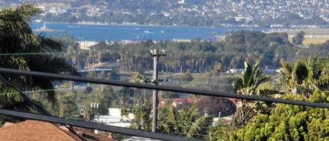 A coastal cityscape with a view of the ocean and hills.