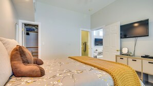 A bedroom with a bed, a wardrobe, a television, and a bathroom visible through an open door. - Luxe Pasadena Casita w/ Fireplace & Grill (Pasadena)