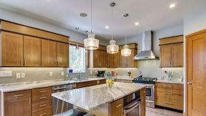 Una cocina moderna con armarios de madera, electrodomésticos de acero inoxidable y encimera de mármol.