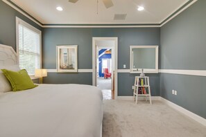 A bedroom with a bed, a nightstand, a lamp, a bookshelf, and a door leading to another room. - Walk to Beach! Group-friendly Ocean City Getaway (Ocean City)