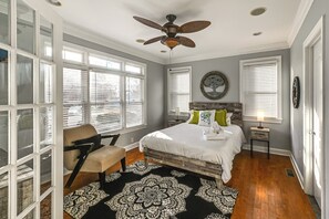 A bedroom with a bed, a chair, a ceiling fan, and large windows. - Walk to Beach! Group-friendly Ocean City Getaway (Ocean City)