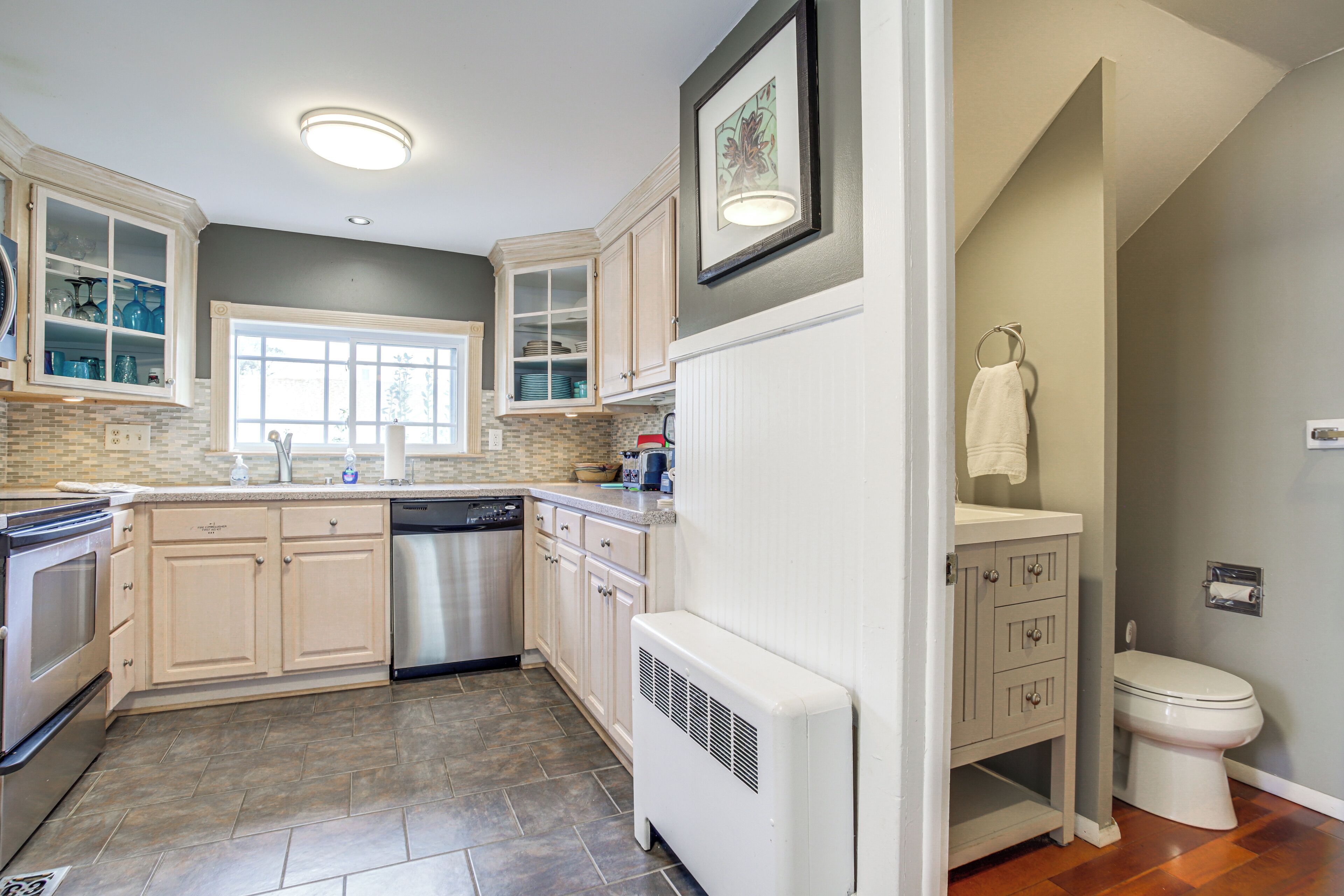 A modern kitchen with built-in appliances, a dishwasher, and a window.