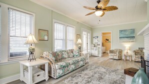 A spacious living room with a sofa, chairs, a ceiling fan, and a large window. - Near Beach & Boardwalk! Group Escape in Ocean City (Ocean City)