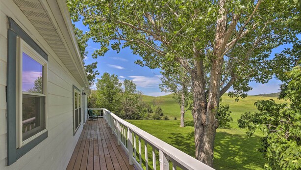 A wooden deck with white railings, overlooking a green landscape with trees and a clear sky. - Hermosa Home w/ Deck: 2 Mi to Custer State Park! (Hermosa)