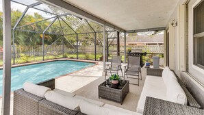 A covered outdoor area with a pool, wicker furniture, and a grill. - Wellington Vacation Rental: Private Saltwater Pool (Wellington)