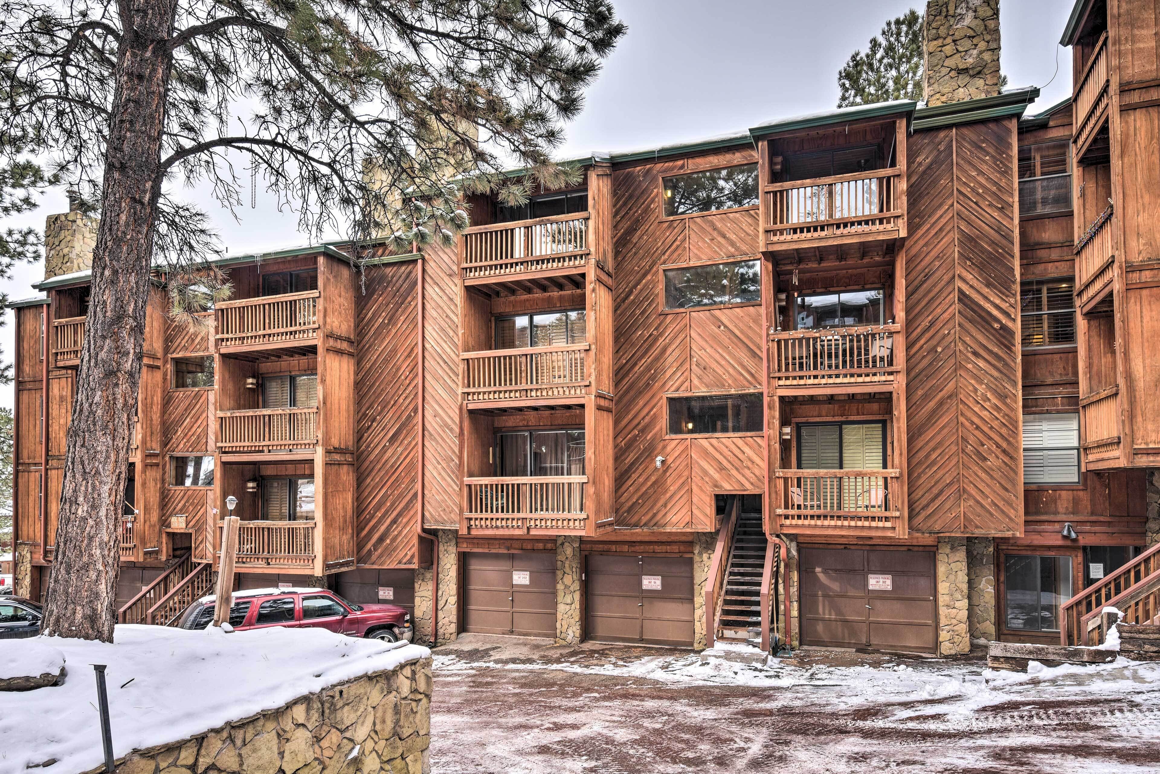 A multi-story wooden building with balconies and a stone facade.