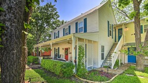 A two-story house with a porch, a front staircase, and a small garden area. - Walk to Main St: Multiple Fireplaces, Jacuzzi Tubs (Fredericksburg)