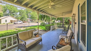 A covered porch with wicker furniture, a ceiling fan, and a view of the street. - Walk to Main St: Multiple Fireplaces, Jacuzzi Tubs (Fredericksburg)