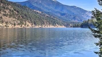 A calm lake with a forested mountain in the background.