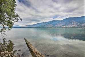 A calm lake with clear water, surrounded by mountains and trees. - Woodsy Riverfront Retreat in Trout Creek Montana! (Trout Creek)