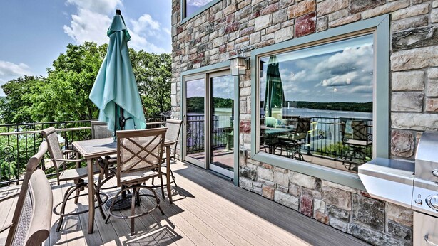 Eine Terrasse mit Gartenmöbeln, einem Grill und Blick auf die Landschaft.