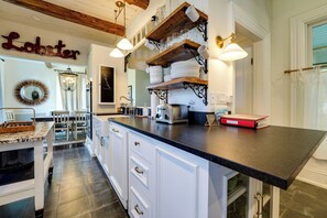 A kitchen with a central island, white cabinetry, and a hanging light fixture. - On-site Pond: Spacious Family Home in Jefferson! (Jefferson)