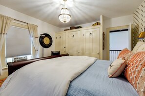 A bedroom with a bed, a clock, a wardrobe, and a window with curtains. - On-site Pond: Spacious Family Home in Jefferson! (Jefferson)
