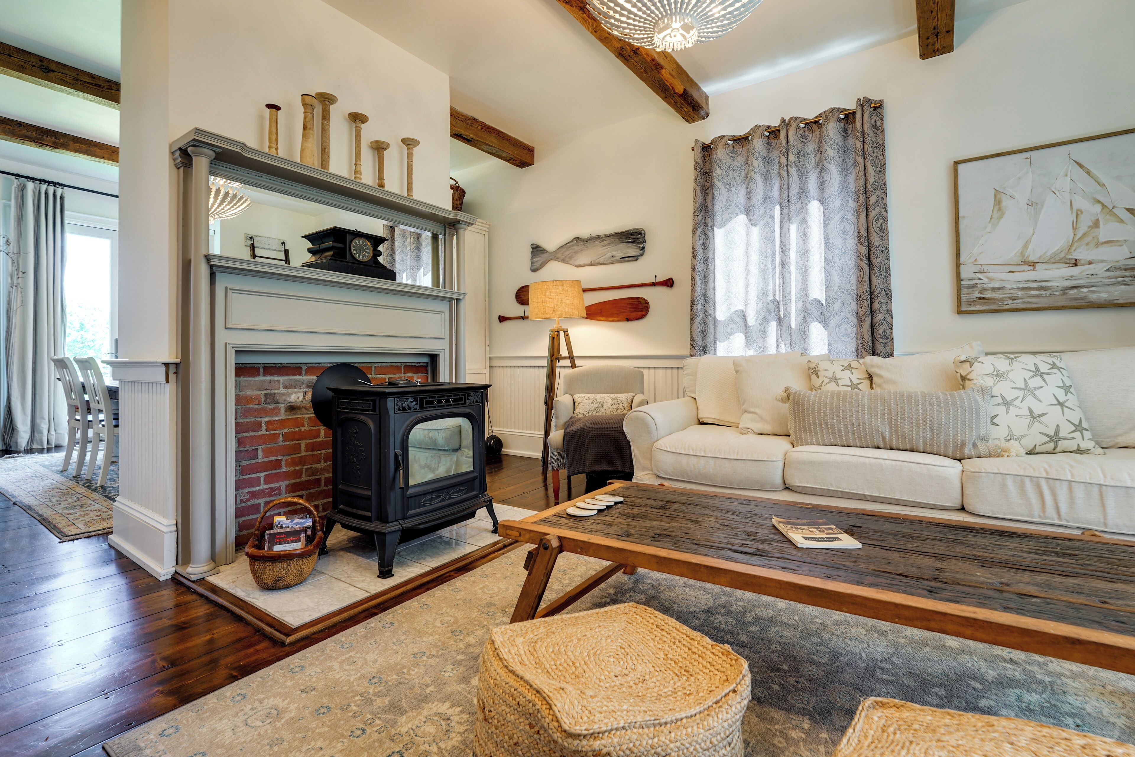 A cozy living room with a fireplace, a sofa, a coffee table, and nautical decor.