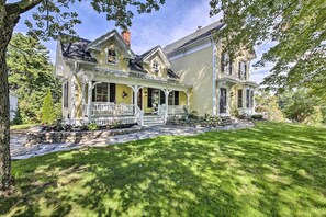 A two-story house with a porch, stone steps, and a well-maintained lawn. - On-site Pond: Spacious Family Home in Jefferson! (Jefferson)