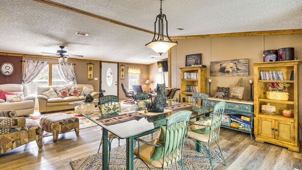 A cozy living room with a dining table, chairs, a sofa, and a bookshelf. - 13 Mi to Silver Springs: Pet Friendly Getaway! (Silver Springs)