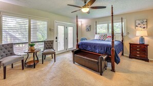 A bedroom with a four-poster bed, two armchairs, a small table with a plant, a nightstand with a lamp, and a ceiling fan. - Relaxing Helotes Apt: 7 Mi to UT at San Antonio! (Helotes)