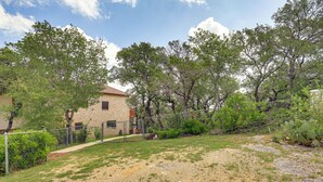 A fenced outdoor area with a gravel path leading to a building with a brick facade. - Relaxing Helotes Apt: 7 Mi to UT at San Antonio! (Helotes)