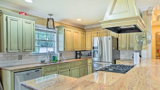 A kitchen with granite countertops, stainless steel appliances, and light green cabinetry. - Charming Lafayette Home ~ 5 Mi to Downtown! (Lafayette)
