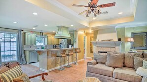 A spacious living room with a large sofa, a coffee table, and a fireplace. - Charming Lafayette Home ~ 5 Mi to Downtown! (Lafayette)