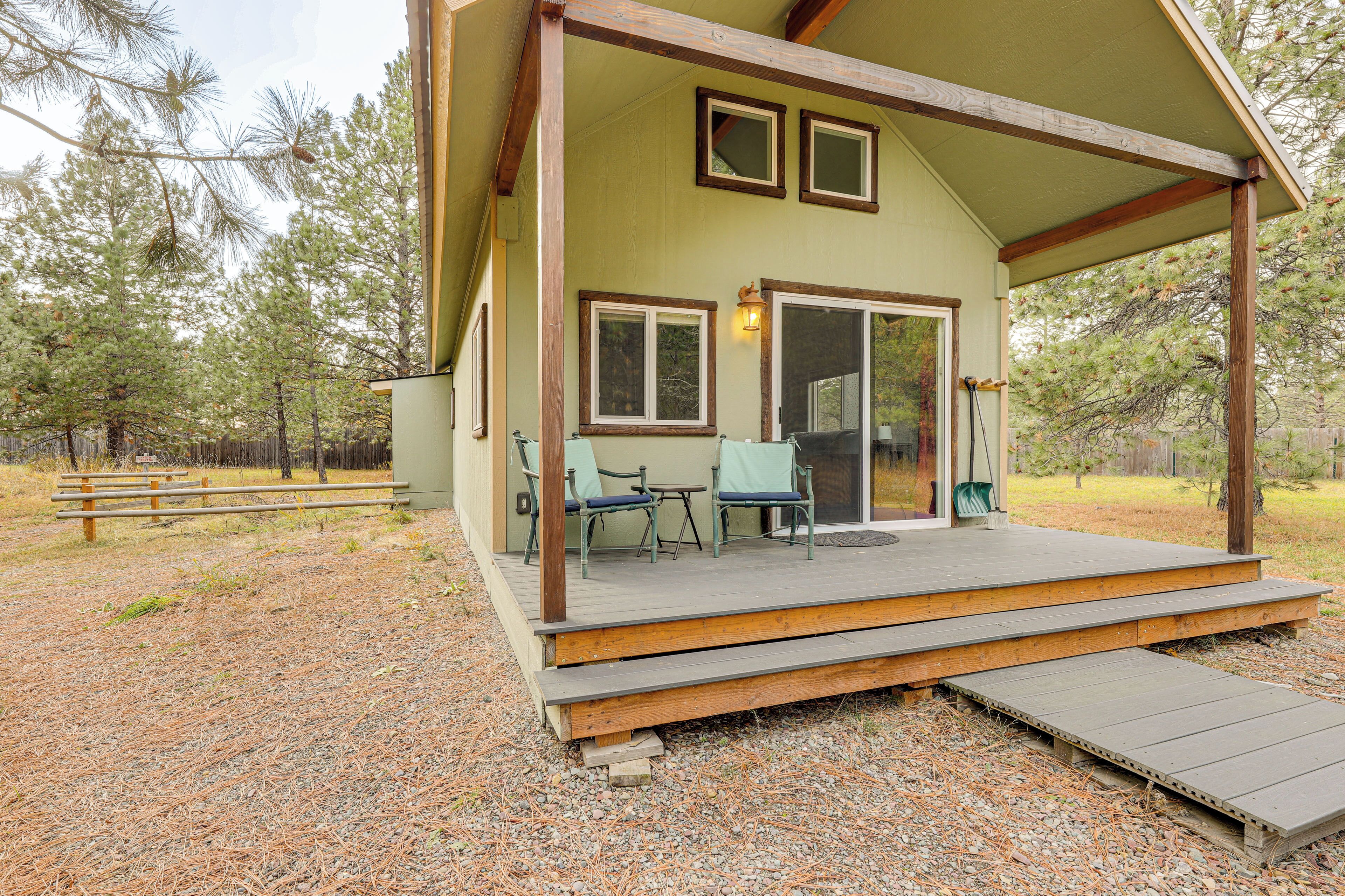 Une terrasse en bois avec des sièges extérieurs et une véranda couverte.