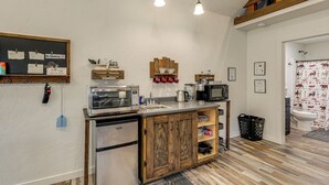 A compact kitchen with wooden cabinets, stainless steel appliances, and a chalkboard with 'No Smoking' signs. - Kalispell Cabin 28 Miles to Glacier National Park! (Kalispell)