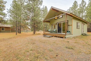 A small cabin with a porch, large windows, and a covered outdoor seating area. - Kalispell Cabin 28 Miles to Glacier National Park! (Kalispell)