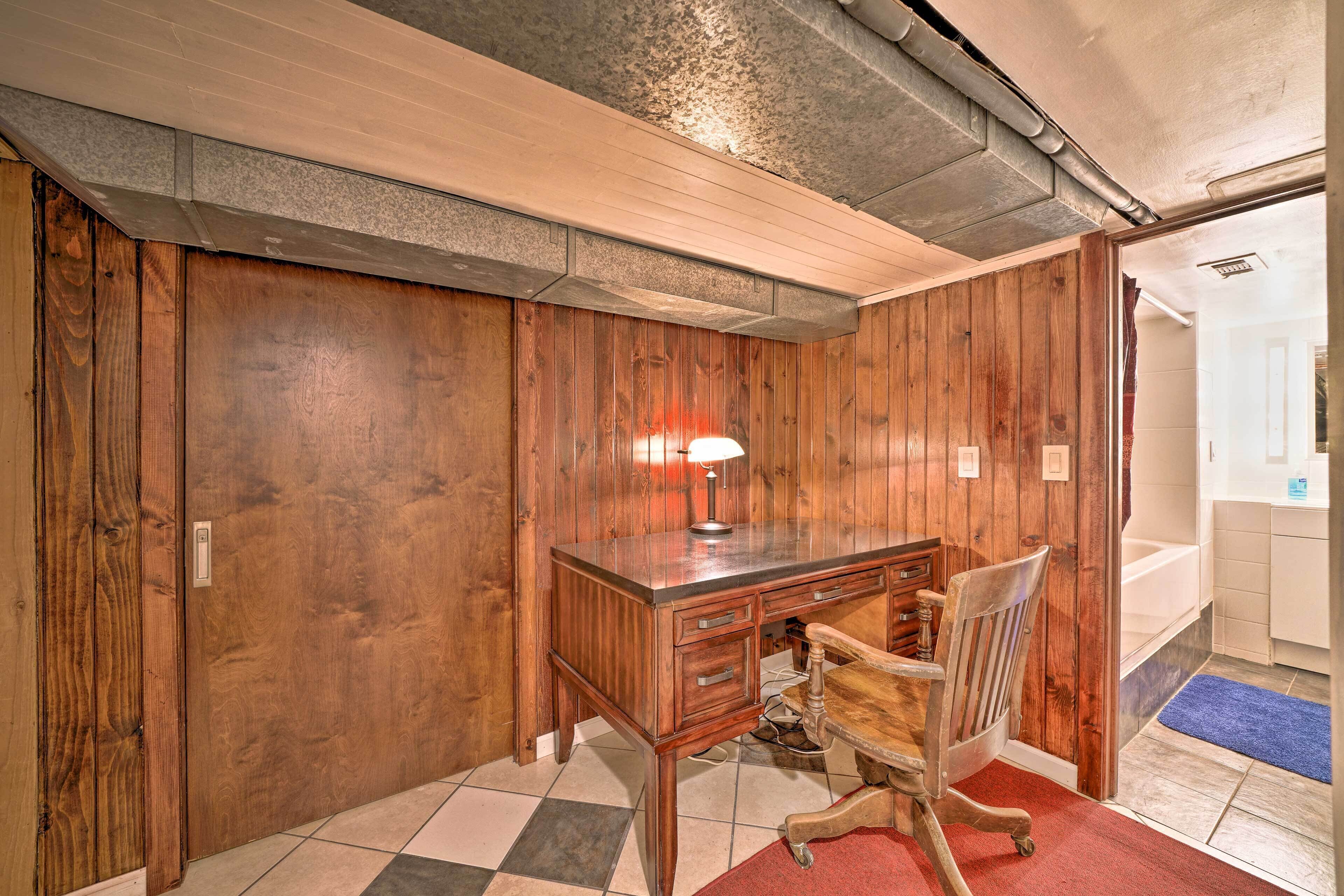 Ein Zimmer mit Holzvertäfelung, einem Schreibtisch, einem Stuhl und einer Lampe.