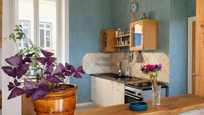 A kitchen with a wooden countertop, a stove, cabinets, and a potted plant with purple leaves. - Charming croix roussien apartment Lyon 1 (THIZY LES BOURGS)