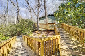 A wooden deck leading to a cabin surrounded by trees. - Private Blue Ridge Retreat: Hot Tub & Pool Table! (Boone)