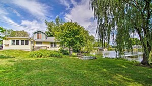 A house with a pond, surrounded by lush greenery and a weeping willow tree. - Rock River Access! Peaceful Horicon Studio (Horicon)
