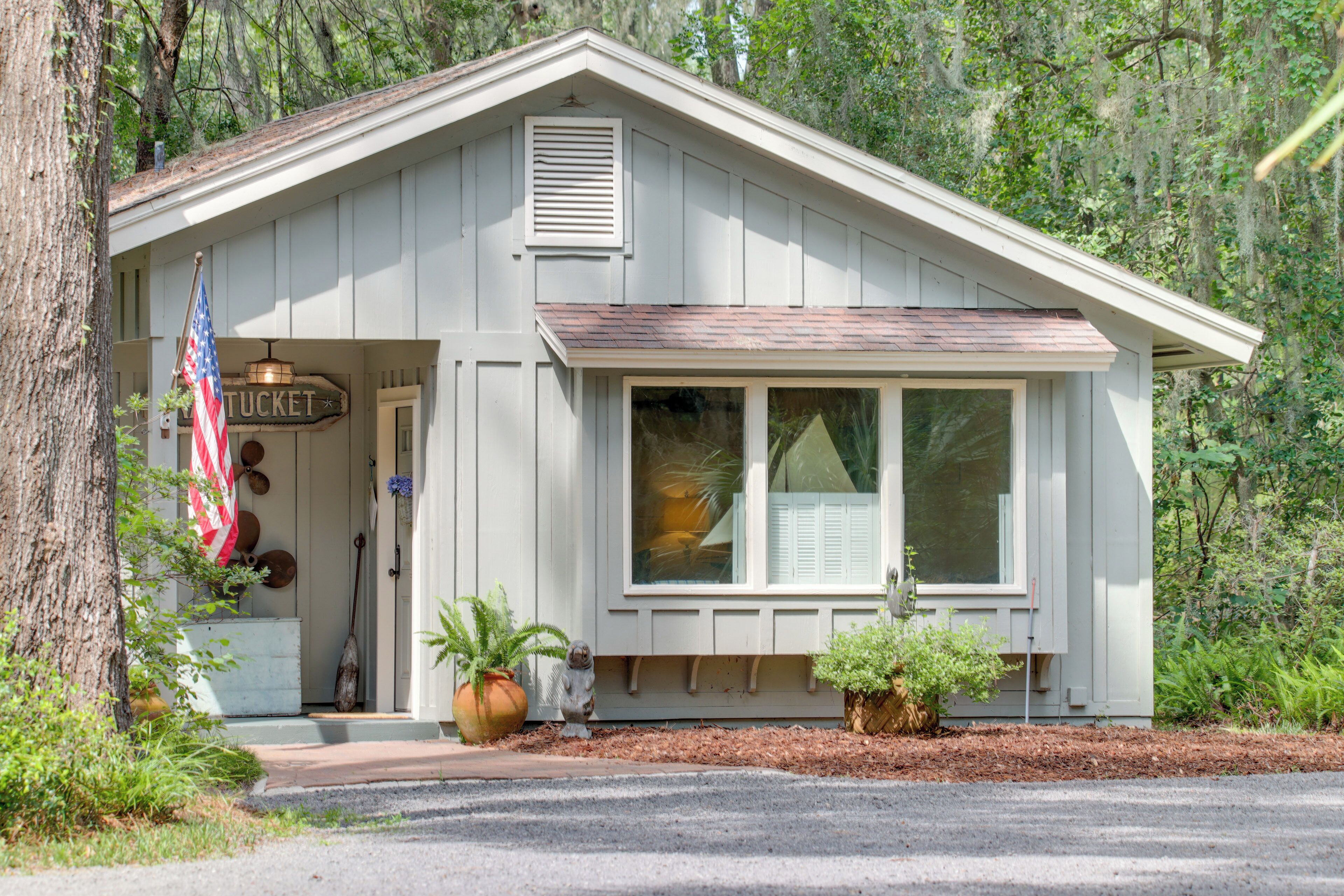 A small, single-story building with a white exterior, a front door, and a window.