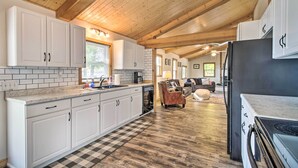 A kitchen with white cabinets, a black refrigerator, and a checkered floor. - Waterfront Onamia Retreat w/ Dock & Fire Pit! (Onamia)