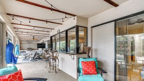 Un espace patio intérieur aménagé avec des sièges, un bar et de grandes fenêtres.