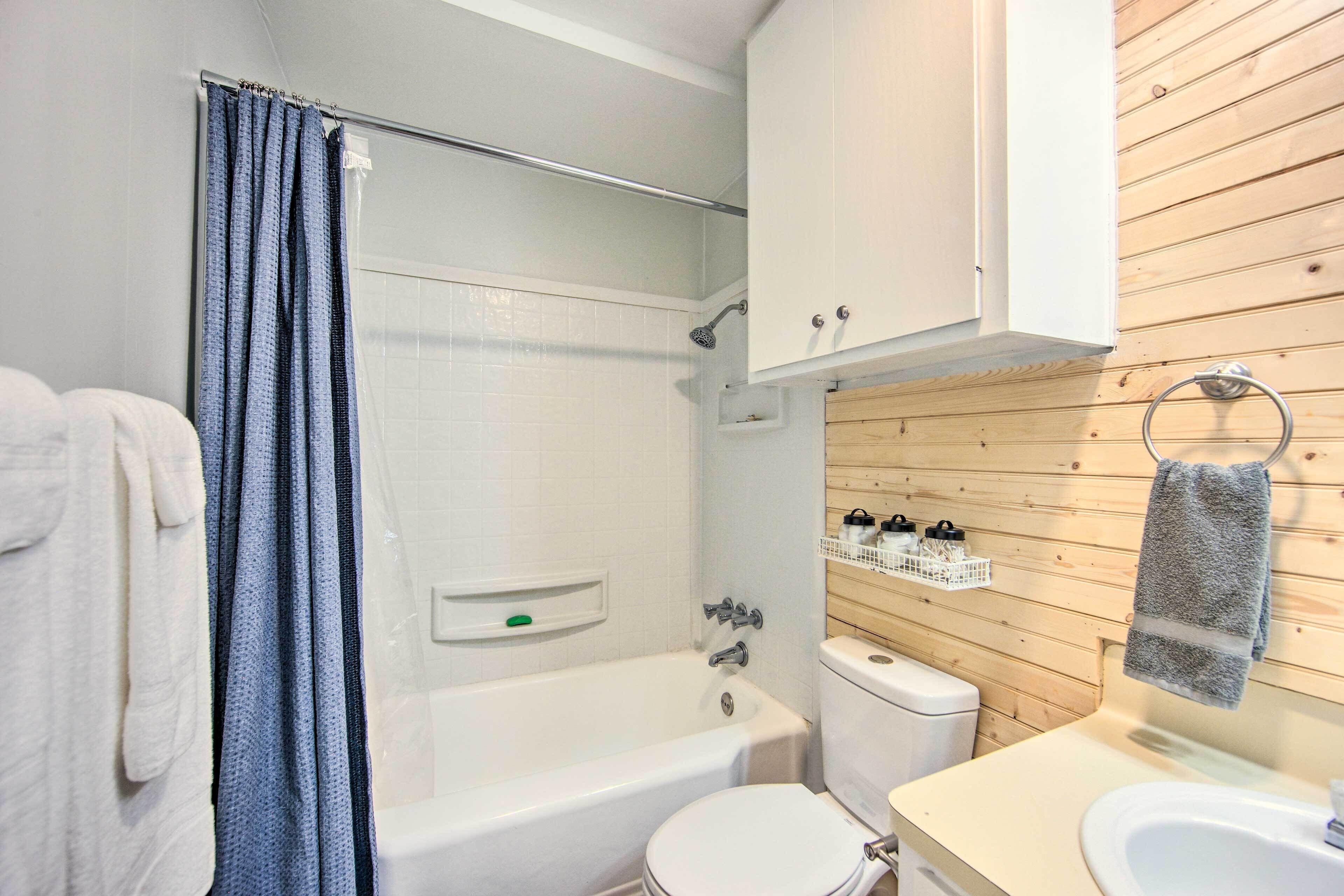 A bathroom with a bathtub, toilet, and sink.