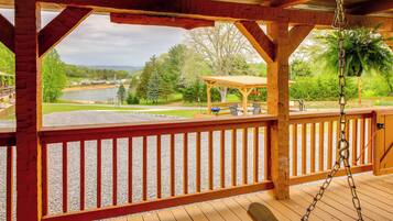 A wooden deck with a view of a lake and trees.