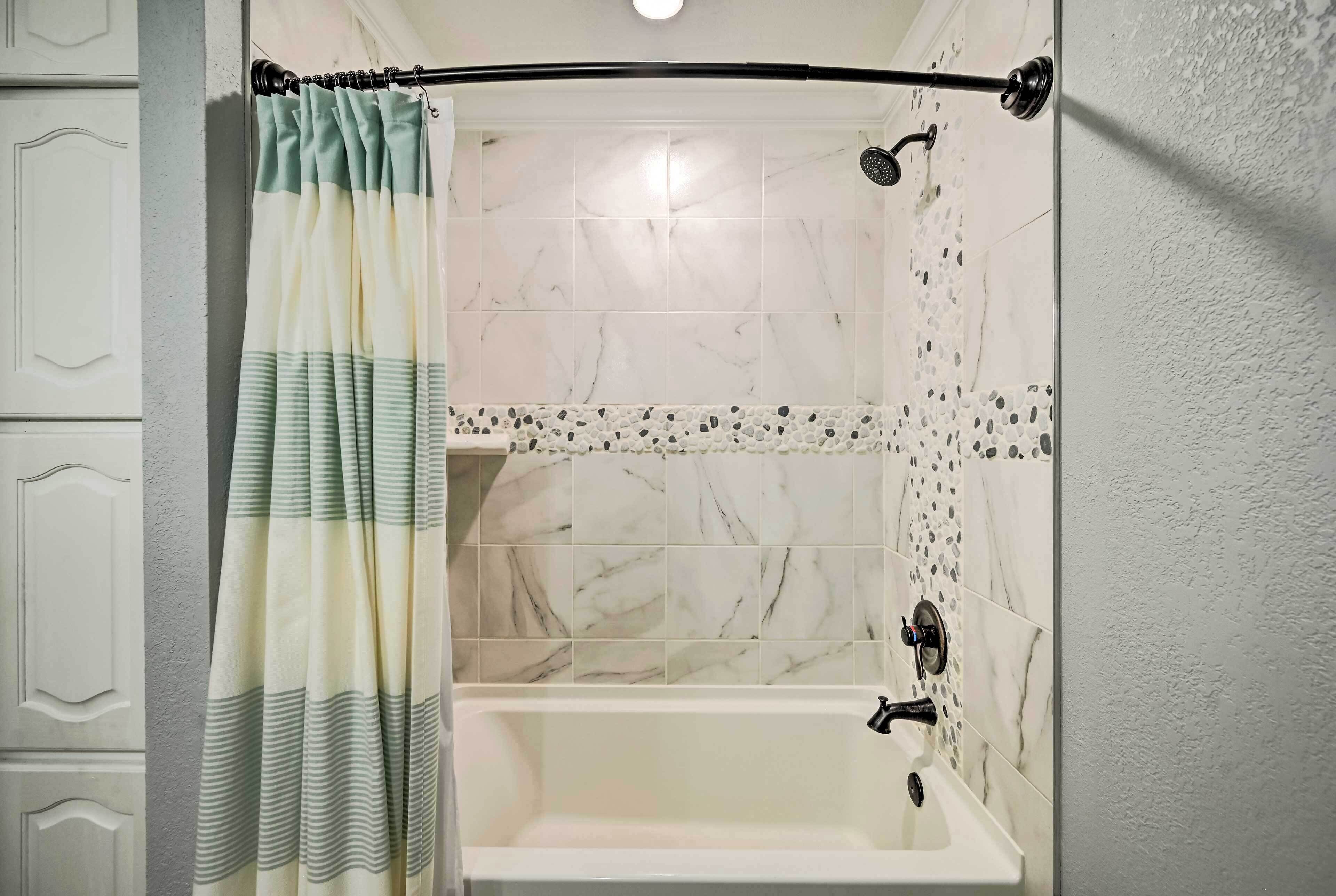 A bathroom with a shower, a bathtub, and a sink.