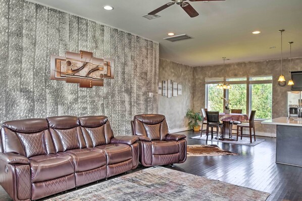 Relax in a spacious living area with a comfortable sofa and recliner, perfect for unwinding and socializing.