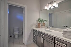 Enjoy a refreshing bathroom experience with a sink, vanity, and mirror, plus a convenient toilet nearby.