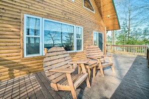 A wooden cabin with a deck, two Adirondack chairs, and a table. - Secluded Lost Lake Cottage w/ Spacious Loft! (Hawks)