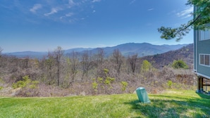 A house with a view of mountains and a grassy yard.