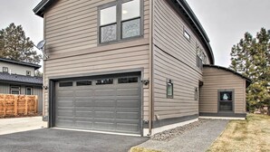 Een twee verdiepingen tellend huis met een garage, een schotelantenne en een klein raam.