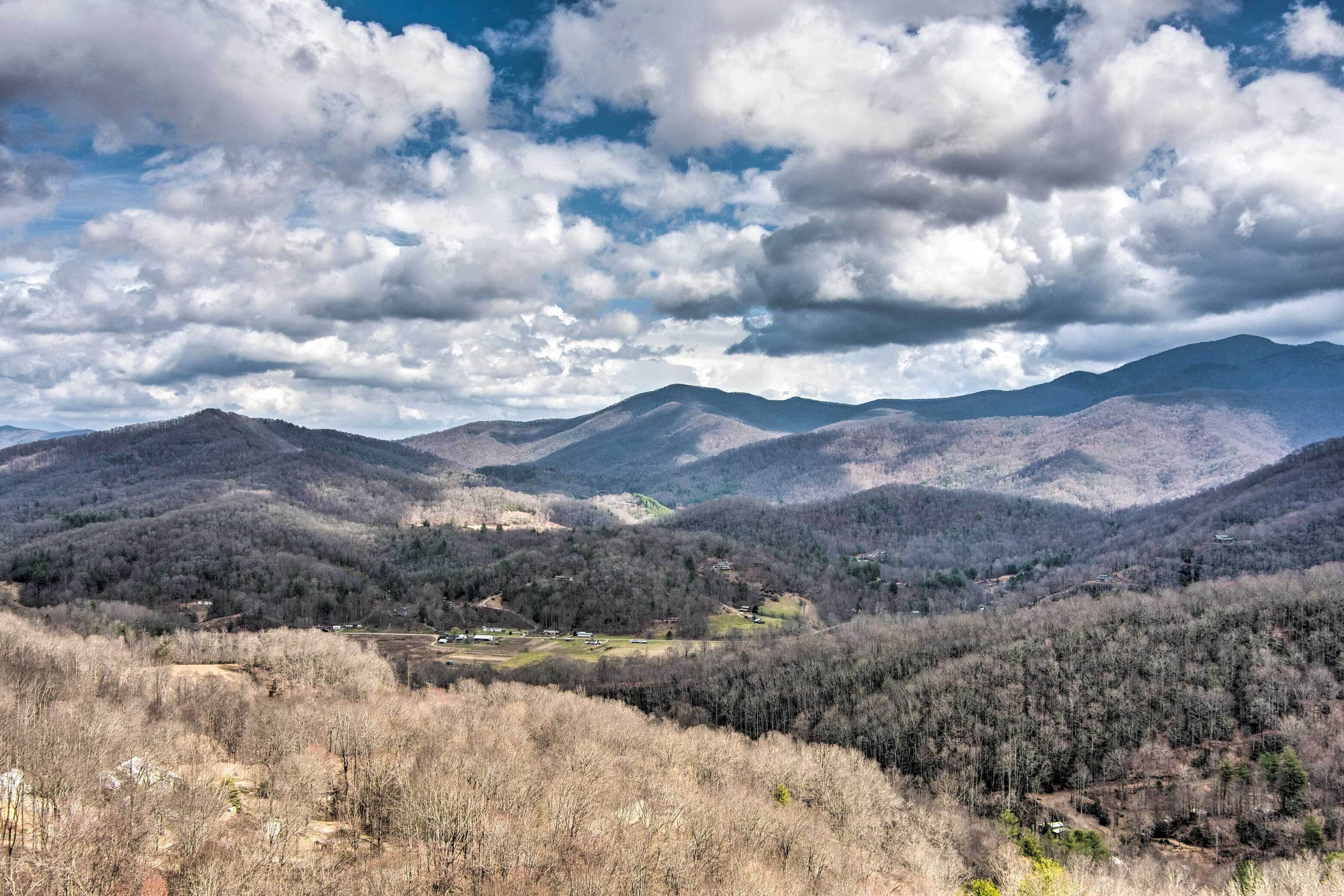 A mountainous landscape with a valley and scattered buildings.