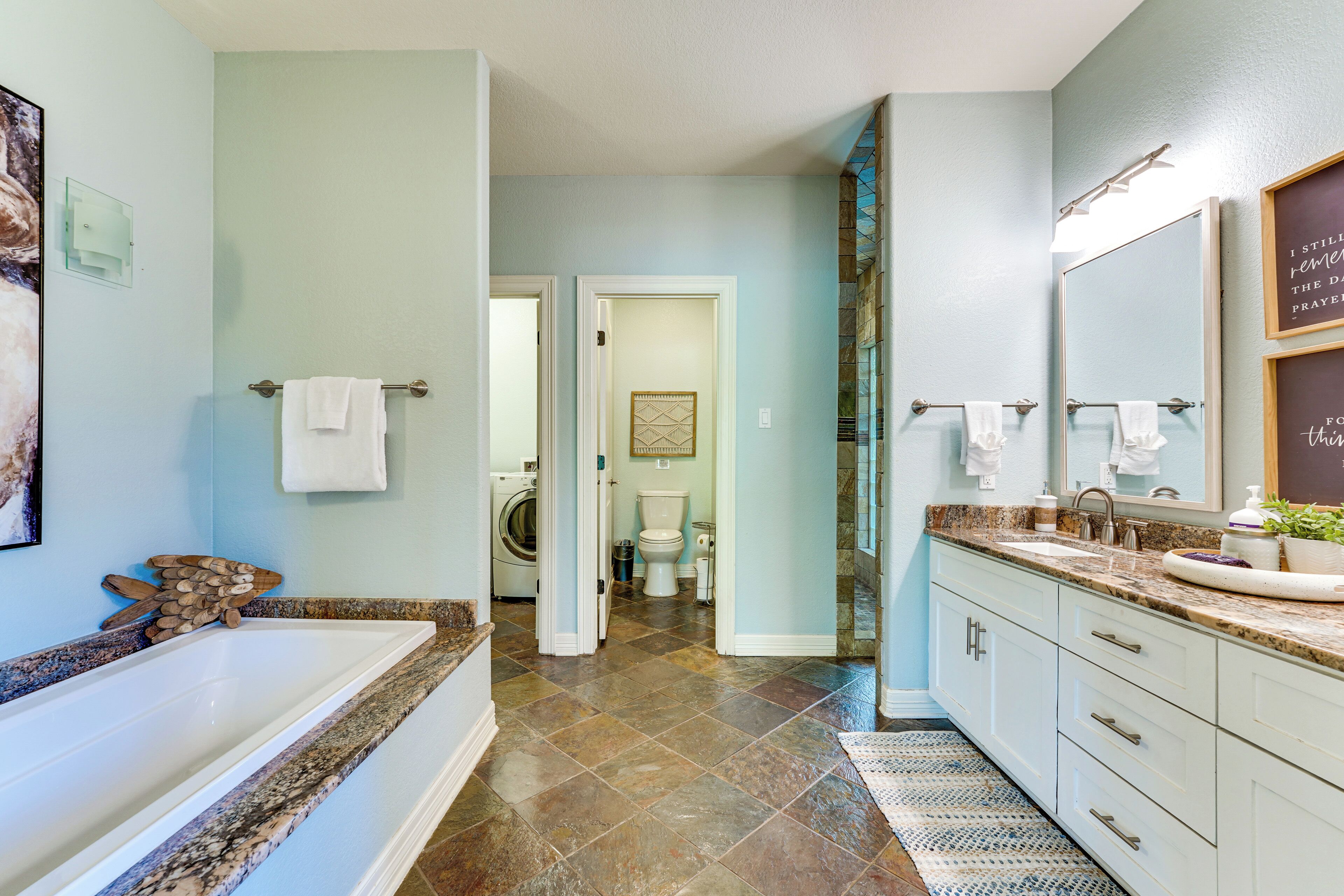 A modern bathroom with a bathtub, a sink, and a toilet.