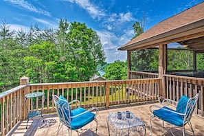 A wooden deck with two metal chairs and a small table, overlooking a lush green landscape. - Charming Getaway w/ Lake Cumberland Views! (Albany)