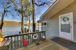 A wooden deck with a railing, a bench, and a welcome sign. - Athens Vintage Fishing Cabin on Elk River! (Athens)