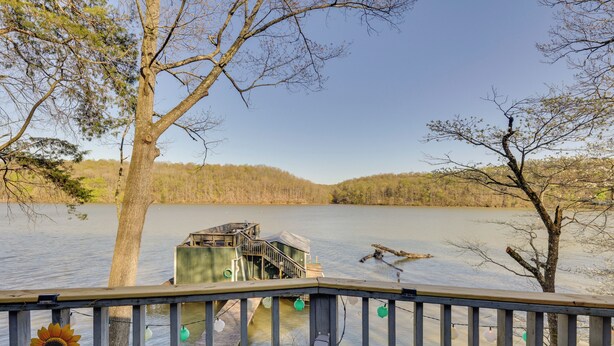 A wooden dock extending into a calm lake, surrounded by trees and a clear sky. - Athens Vintage Fishing Cabin on Elk River! (Athens)