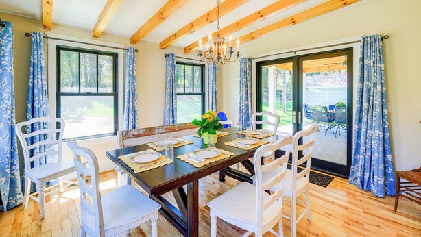 A dining area with a wooden table set for four, white chairs, and a chandelier. - Stunning Damascus Vacation Rental w/ Fire Pit! (Damascus)