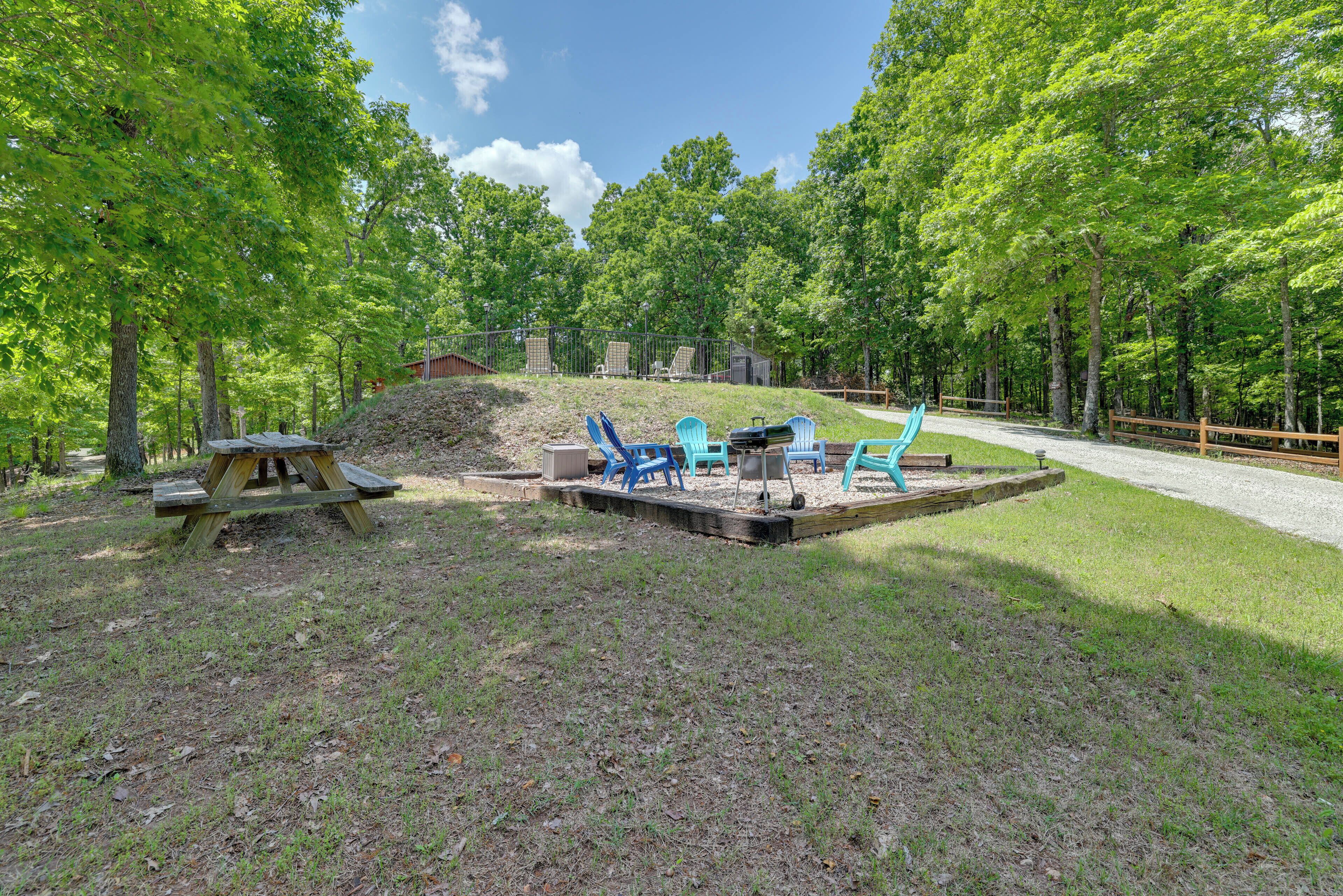A picnic area with a wooden table and benches, surrounded by trees.