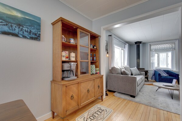 A living room with a wooden cabinet, a grey sofa, and a blue armchair.
